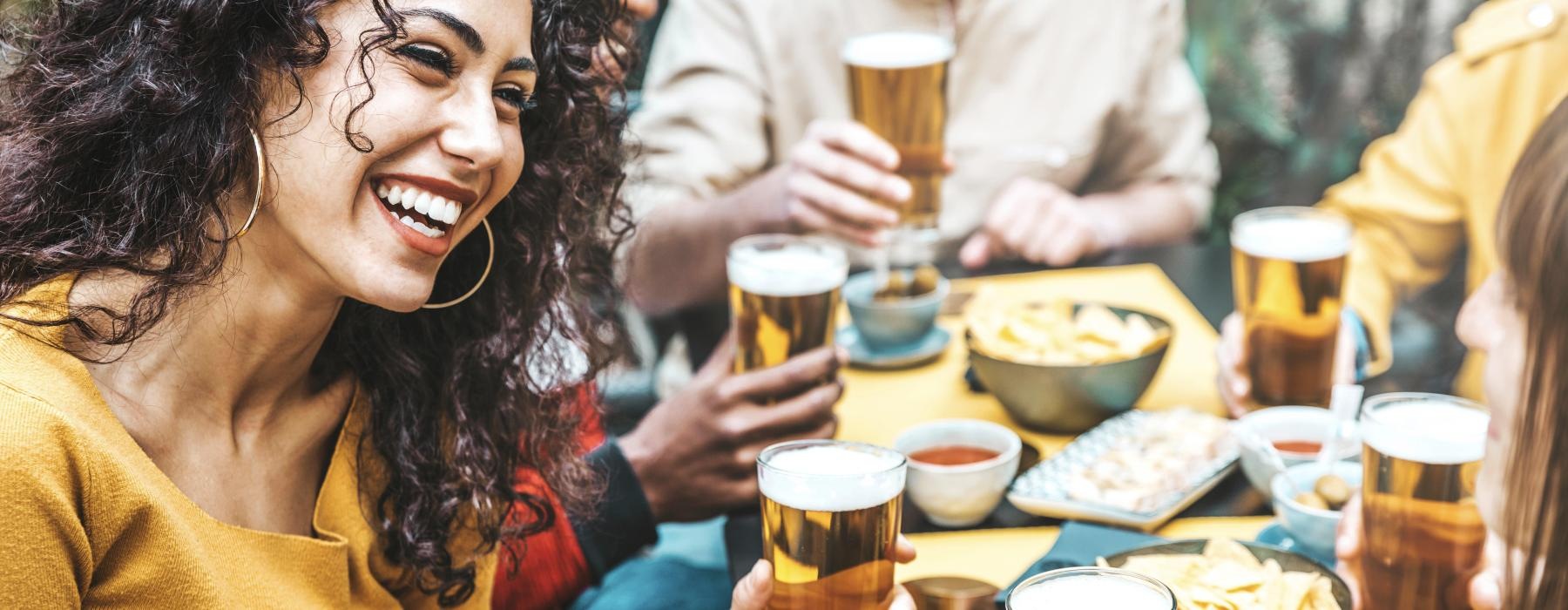 a person smiling and holding a glass of beer